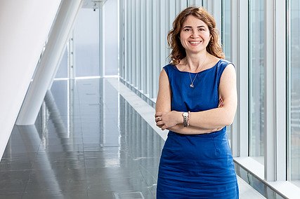 Melis stands in her office at STRABAG and smiles at the camera