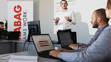 Photo Man presenting with both hands in a seminar room