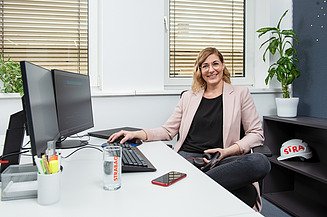 Marion, IT software developer at STRABAG, sitting at her desk in the office