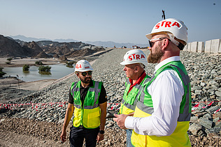 Colleagues stand together on the construction site in Oman