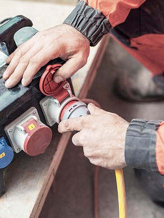 Foto Mann steckt ein Kabel an 