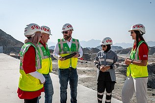 Colleagues stand together on the construction site in Oman