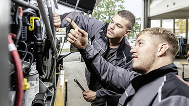 Photo Two men working at a device the front shows up